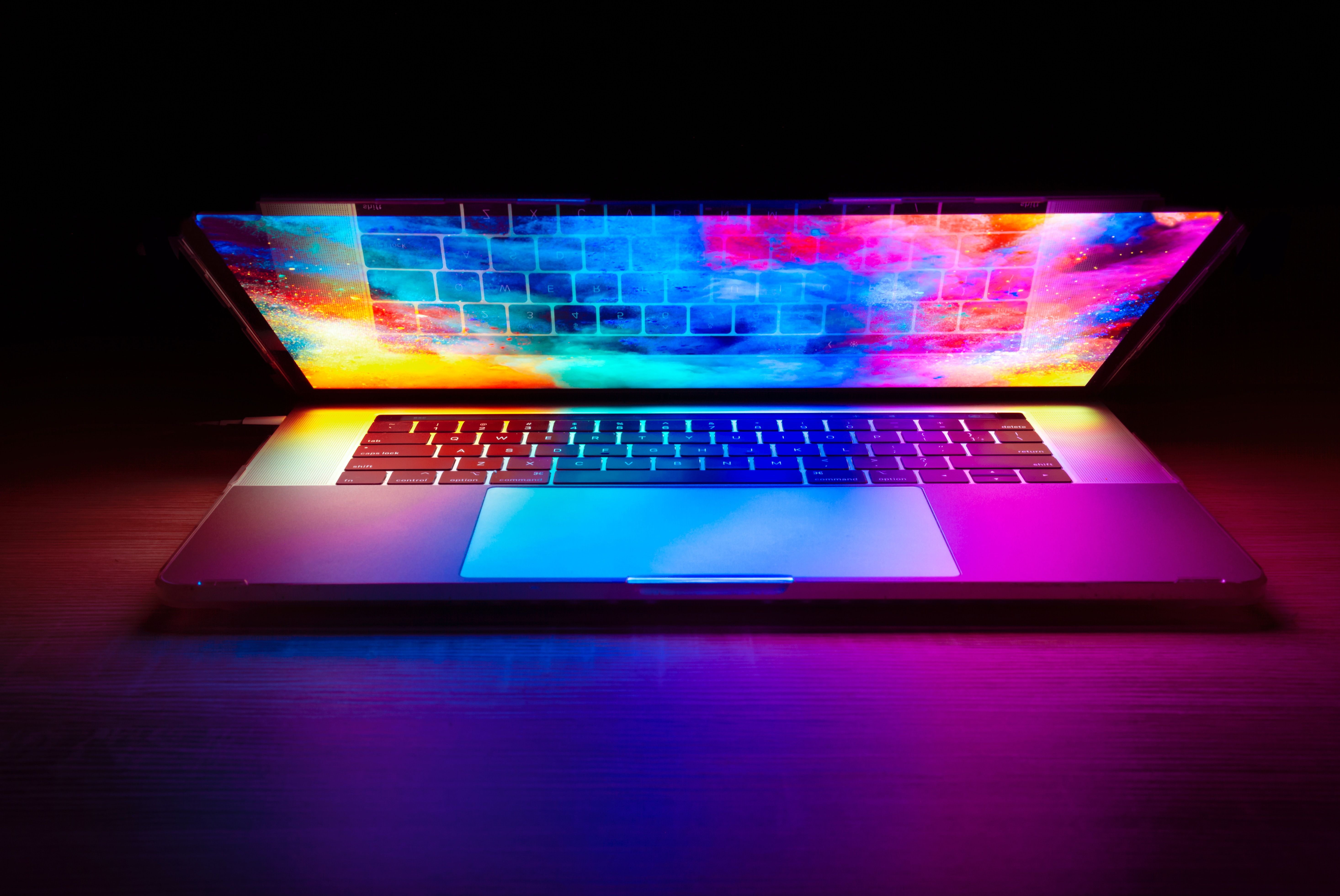 image of an opened laptop with a dark and colorful background